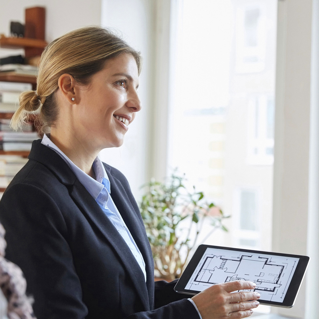 Mäklare som visar en planlösning på en ipad